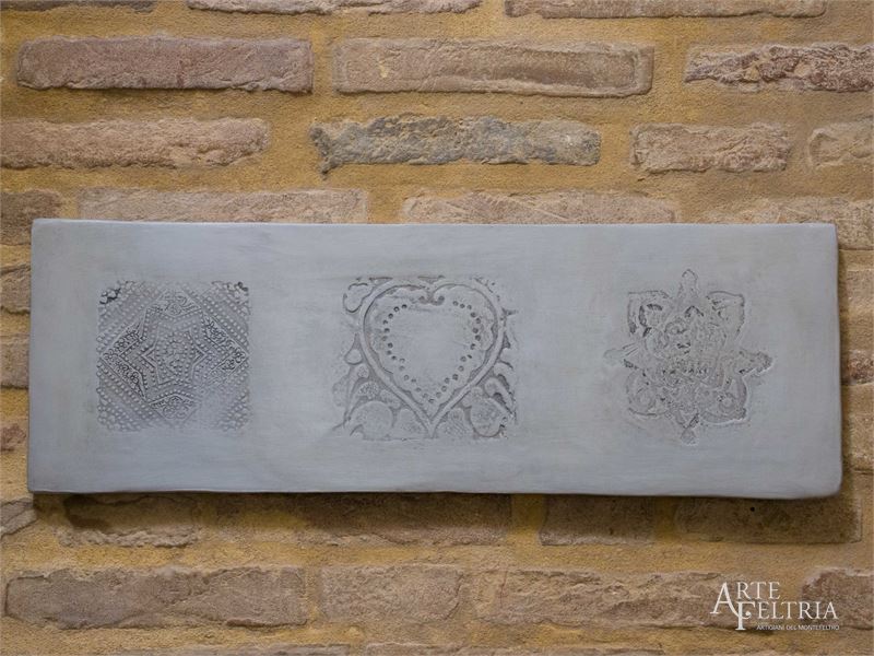 Formella rettangolare con rosone, cuore e stella, grigia
